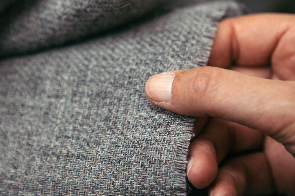 Hand hält Möbelstoff