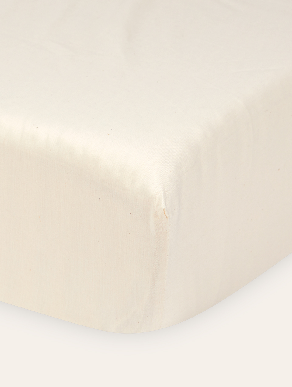 Ecke einer Naturmatratze bespannt mit Leintuch