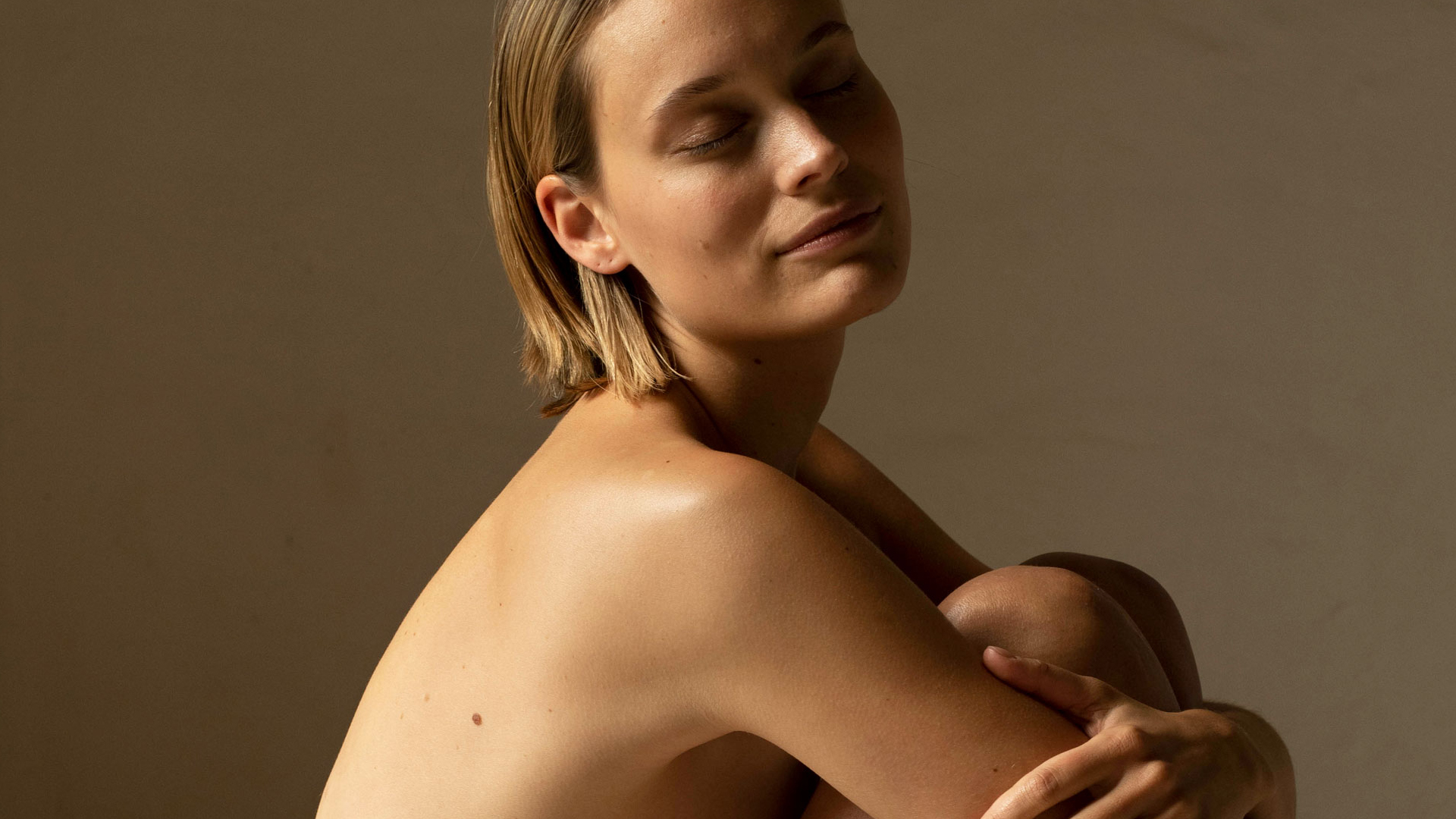 Frau sitzt mit den Knien vor der Brust