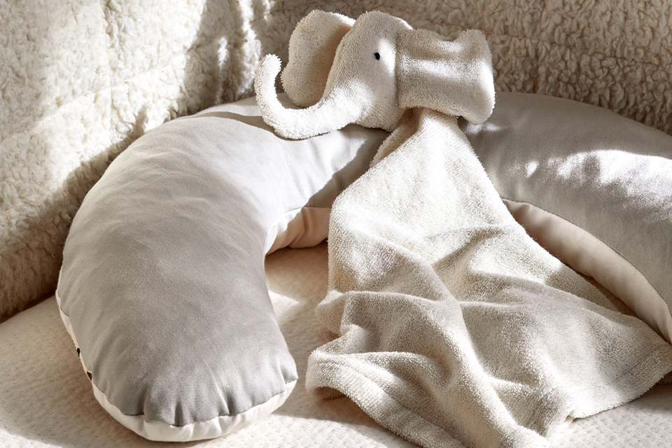 Nackenkissen und Schmuselefant in einem Bett
