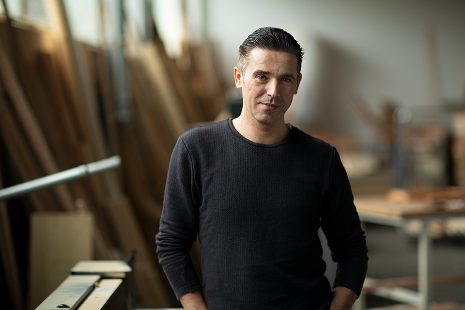 Lächelnder Mann steht in einer Werkstatt