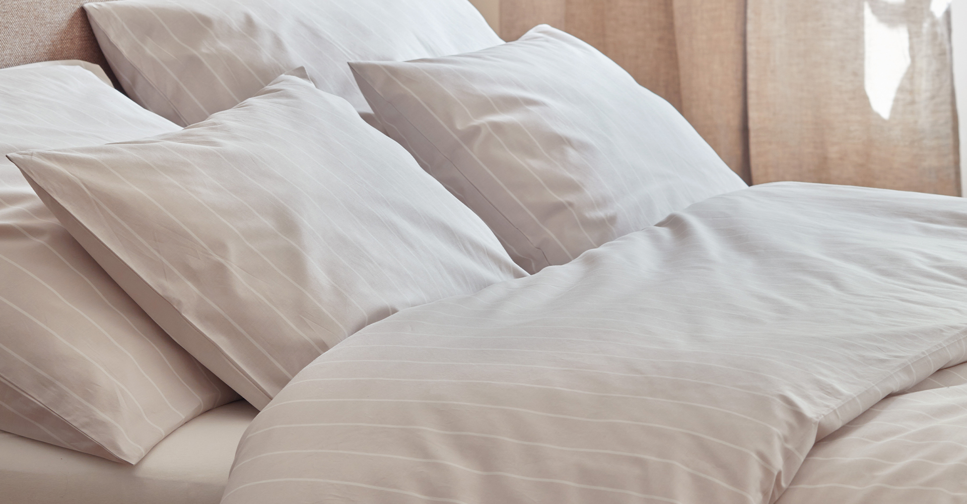 Gestreifte Bettwäsche liegt im Bett