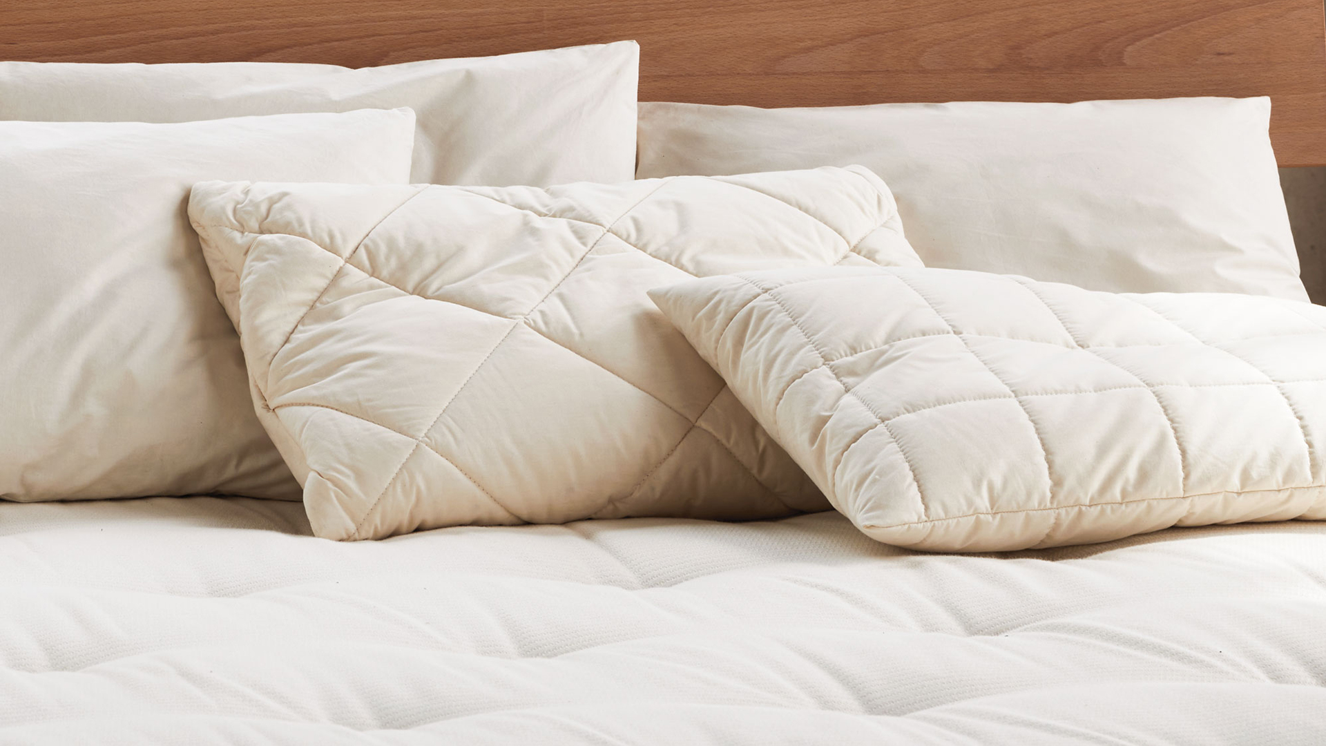 verschiedene hochwertige Schlafkissen auf Naturmatratze