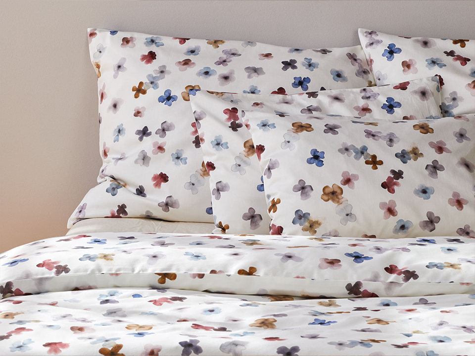 Grüne Bettwäsche auf einem Bett drapiert