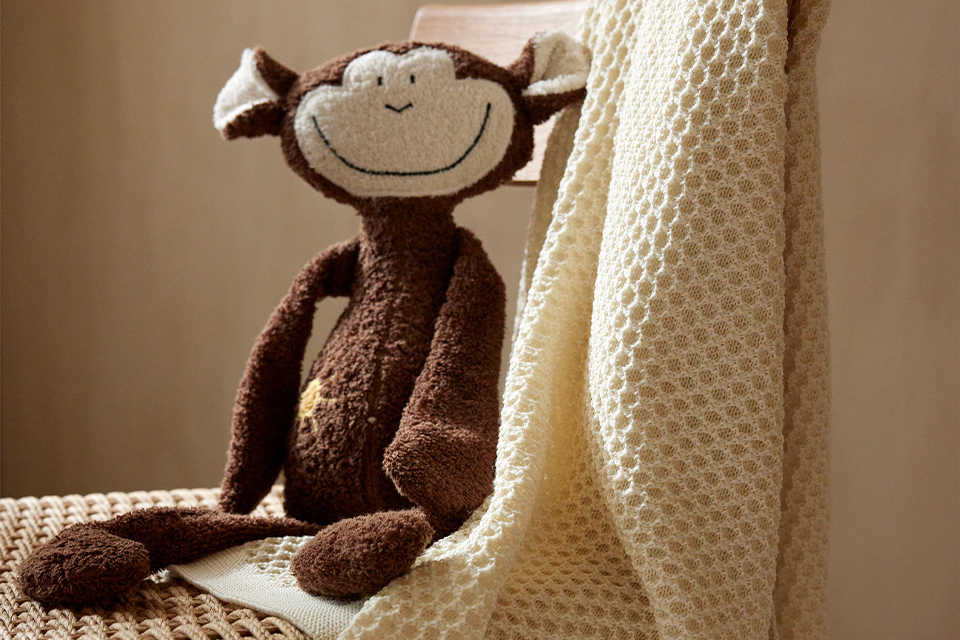 Affe Abu auf einem Stuhl sitzend