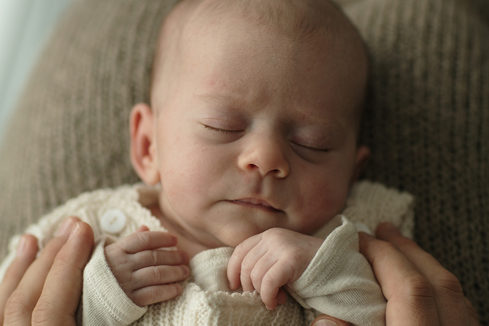 Ein Schlafendes Baby wir im Arm gehalten