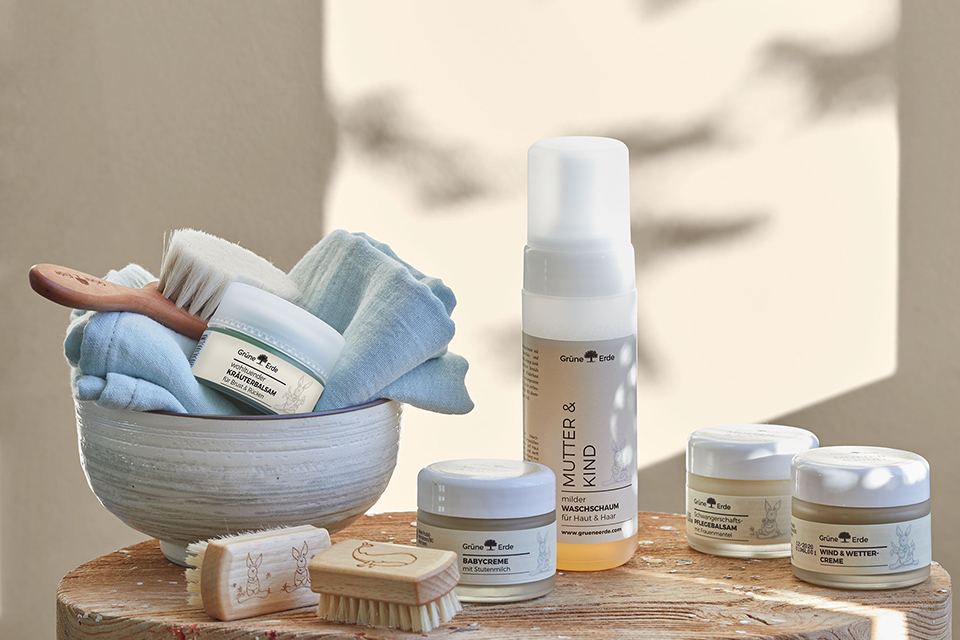 Baby-Badepflegeprodukte mit Bürsten auf einem dekorativen Baumstumpf