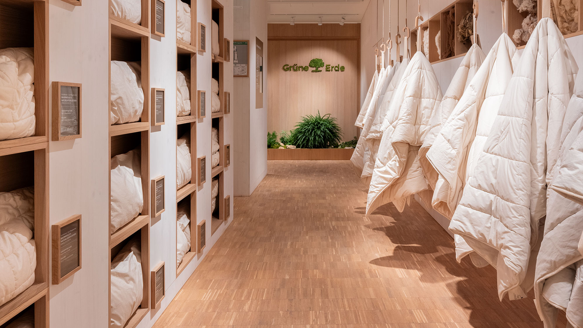 Innenansicht eines Stores mit Regalen und hängenden Bettdecken