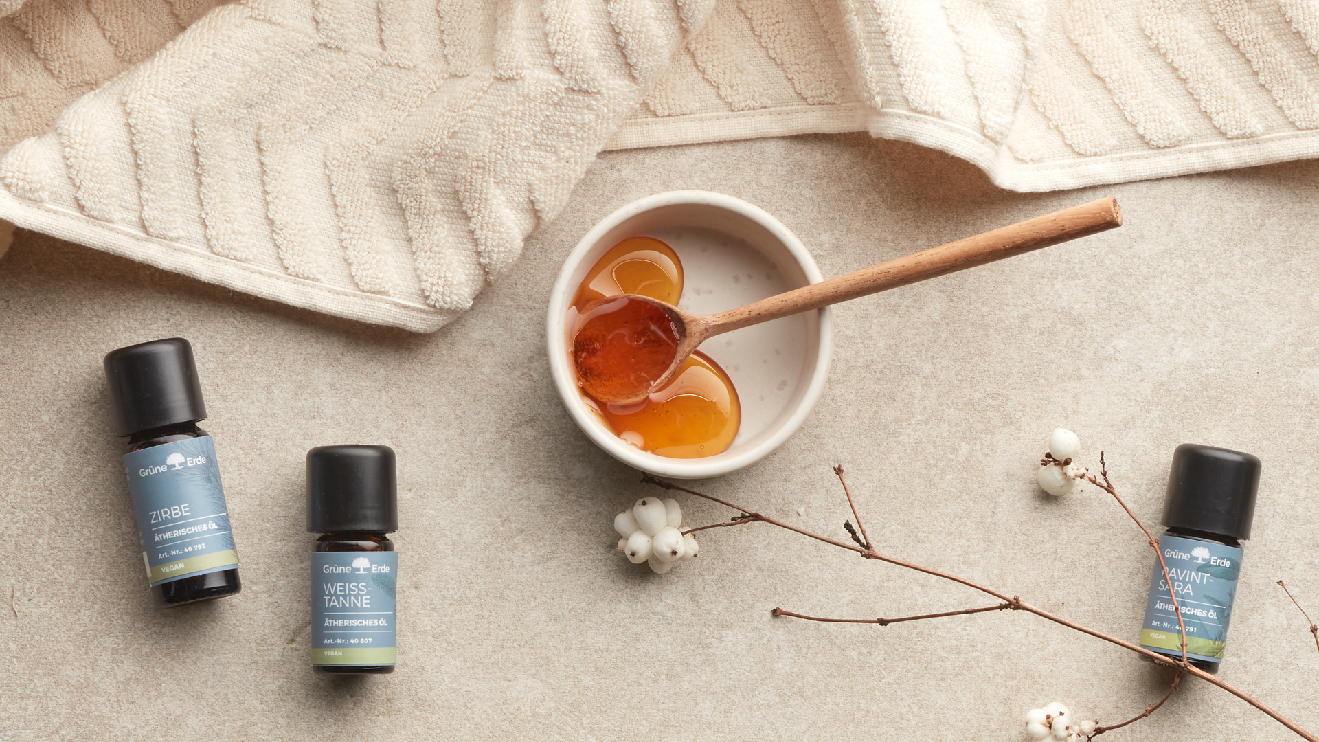 Ätherische Öle neben einer Schale mit Honig