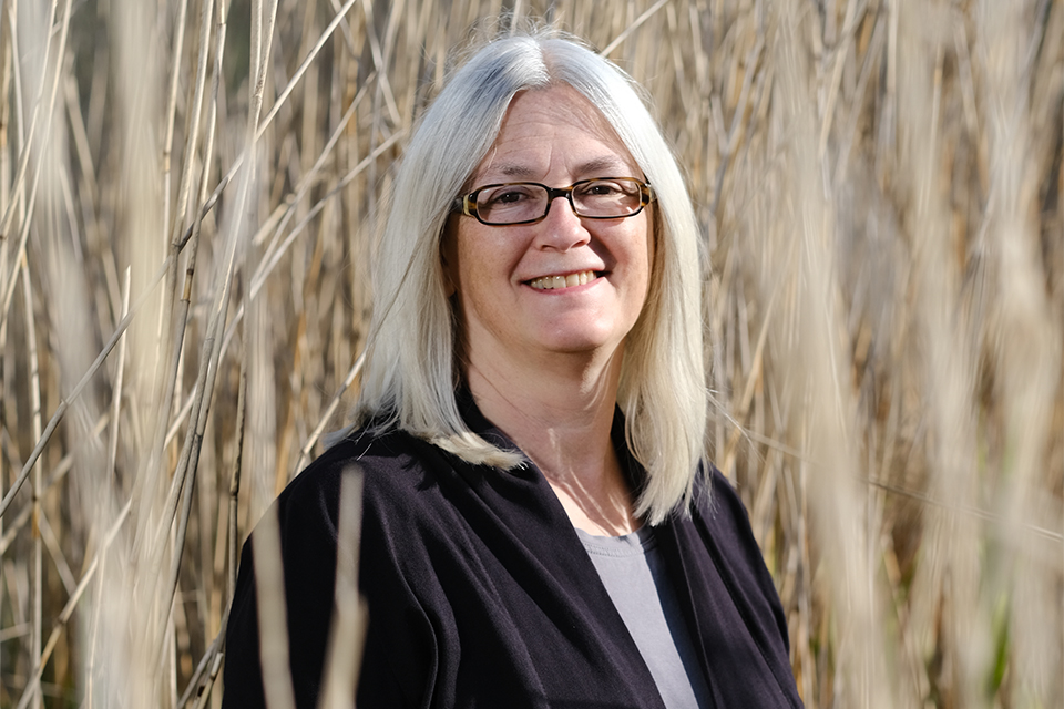 Lächelnde Frau steht im Schilf