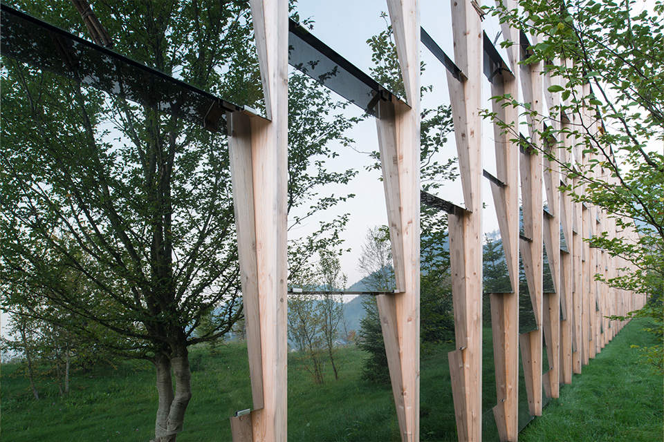 Moderne Holzfassade mit vertikalen Elementen im Grünen