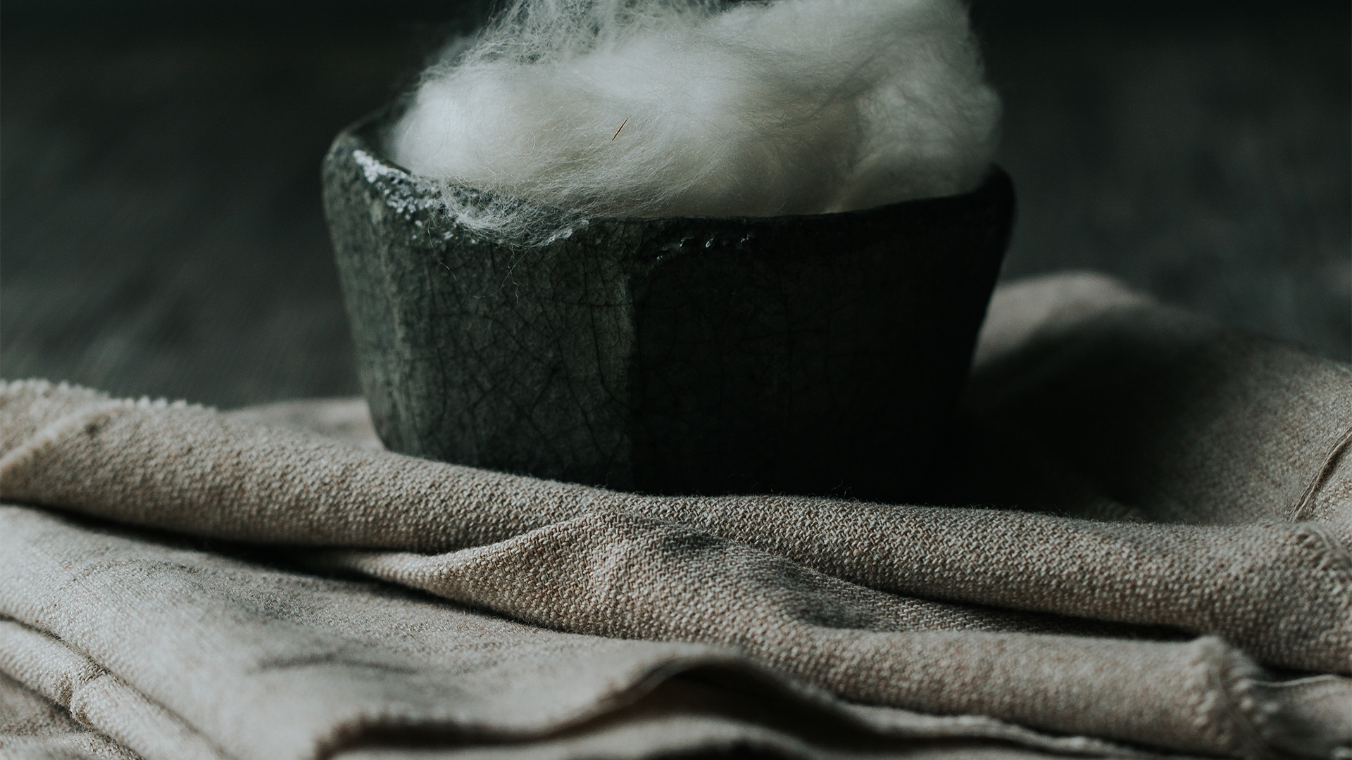 Gefäß mit Wolle steht auf Stofffetzen