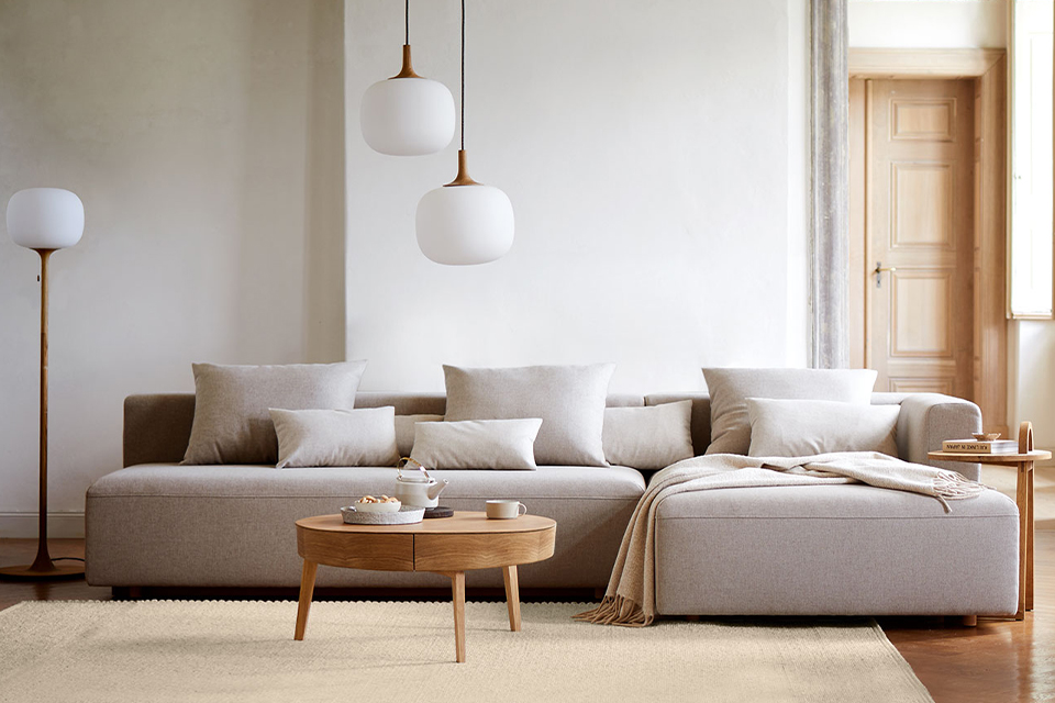 Modernes Wohnzimmer mit grauem Polstersofa und einem Holztisch