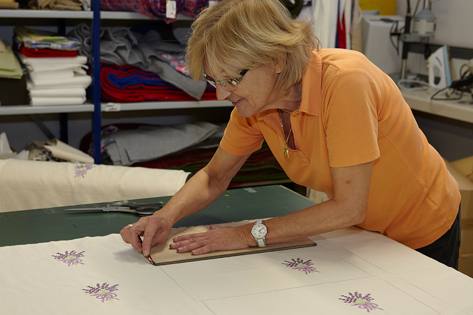 Mitarbeiterin schneidet die Stoffe für Lavendelkissen