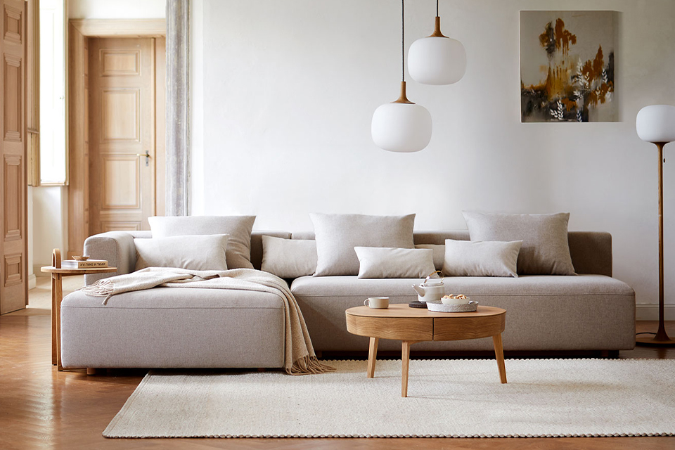 Gemütliches Wohnzimmer mit großem Sofa und minimalistischer skandinavischer Einrichtung