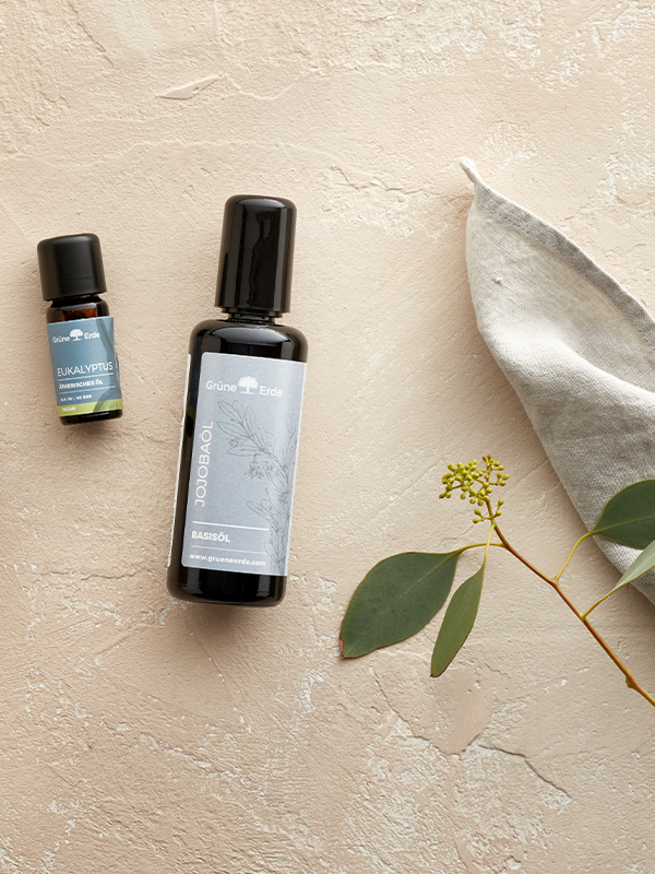 Basisöl und Aromaöl neben einer Schüssel mit Öl gefüllt