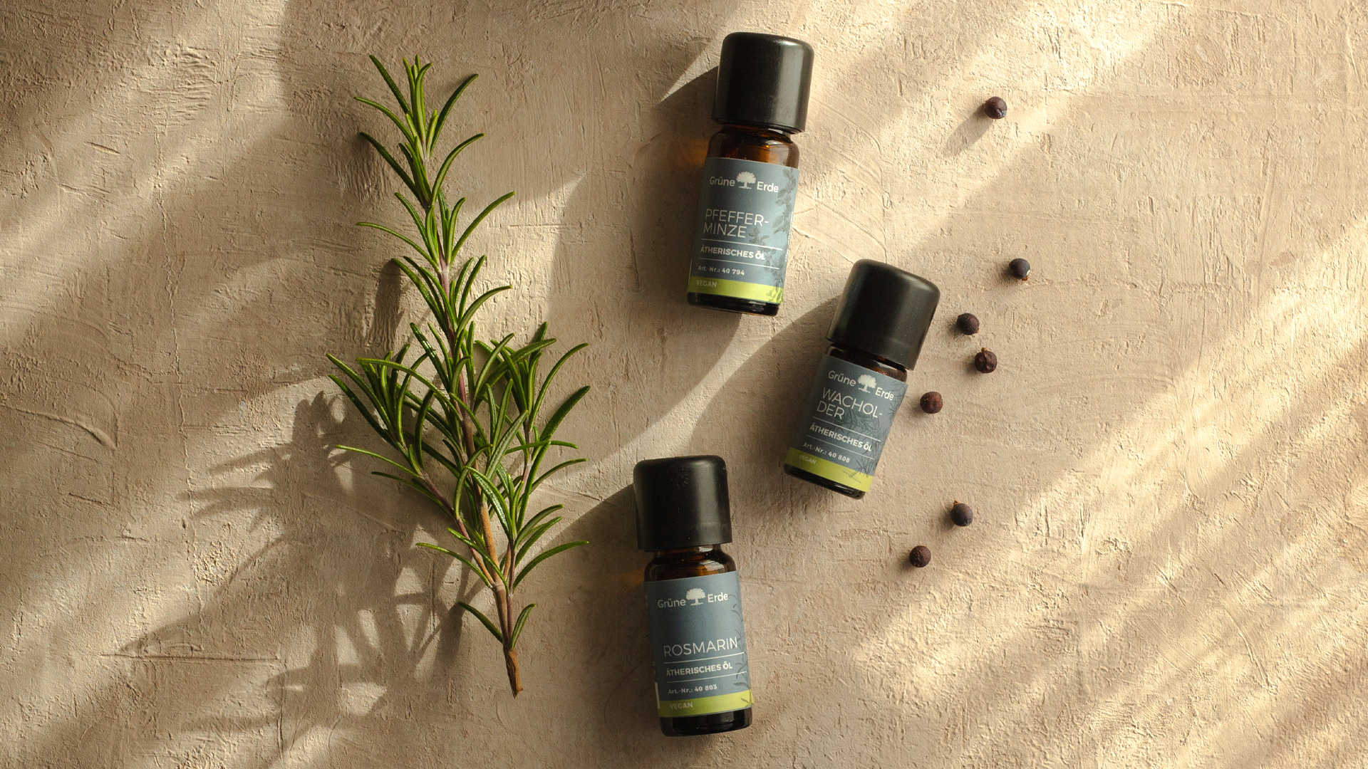 Aromaöle neben einem Rosmarinzweig und Körnern