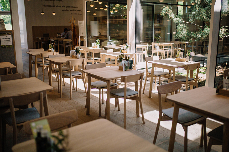 Bistrobereich mit Holztischen und natürlicher heller Atmosphäre
