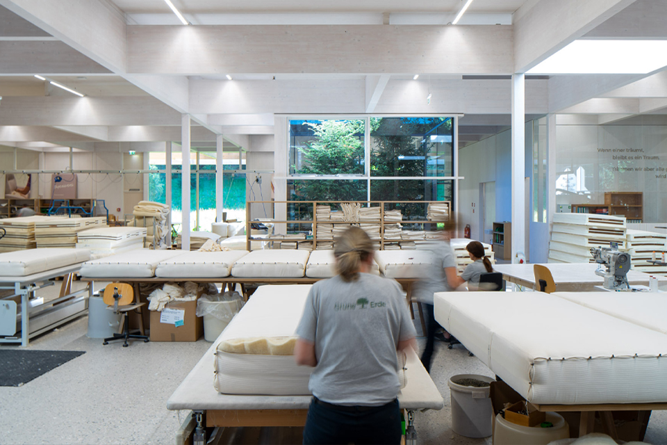 Mitarbeiterin in der Grünene Erde Produktion steht in der Produktionsstätte