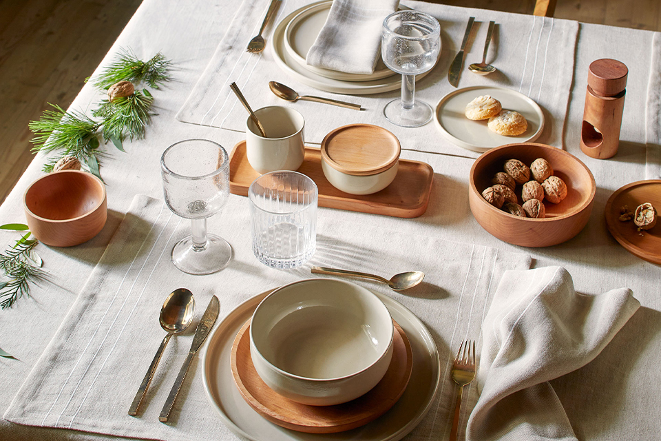 Stilvoll gedeckter Tisch mit Geschirr und natürlichen Materialien