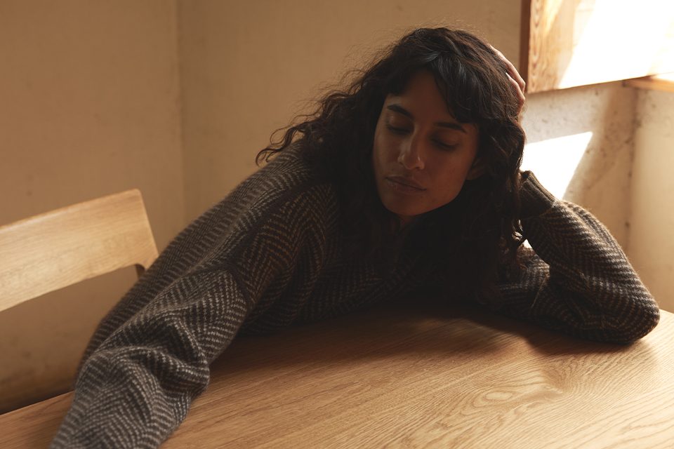 Eine Frau sitzt an einem Massivholztisch