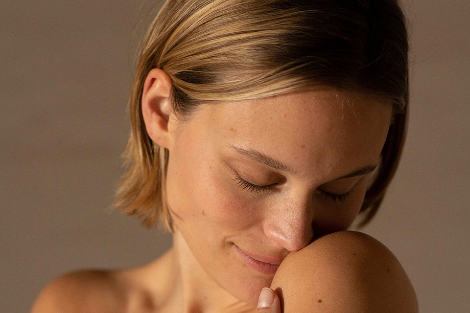 Frau neigt ihren Kopf auf ihre Schulter