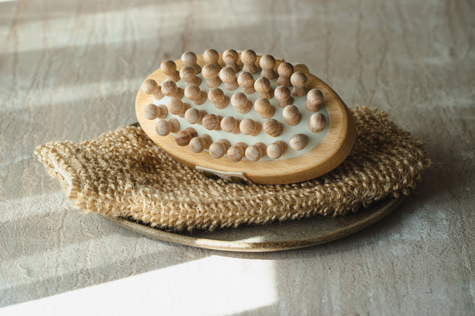 Zellulitebürste liegt auf einem Waschlappen auf einem Teller