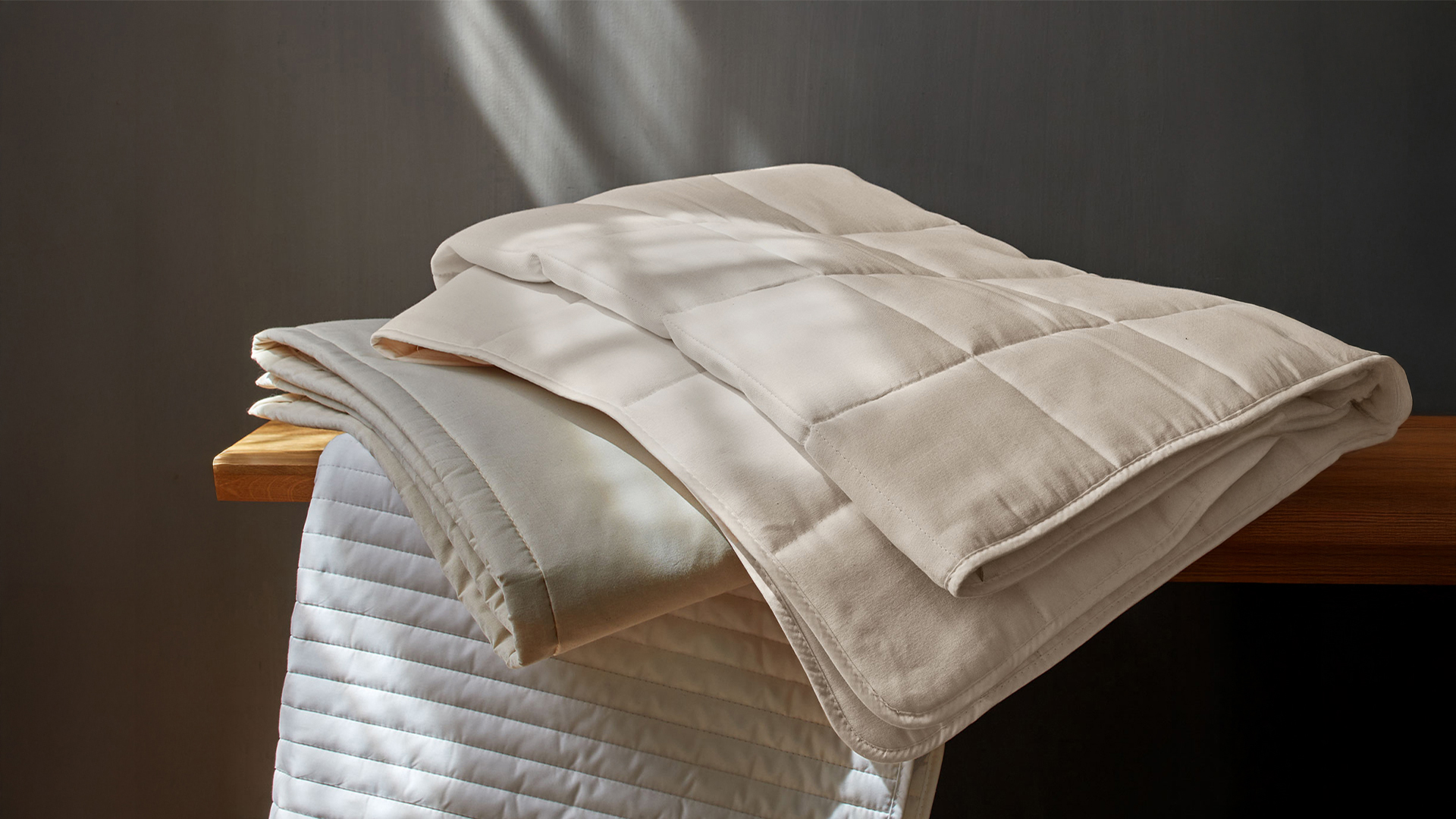 verschiedene Auflagen liegen auf einer Holzbank