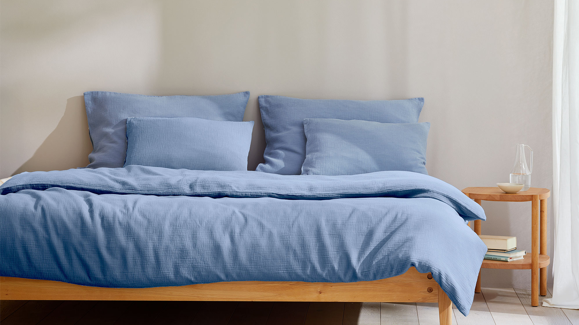 Blaue Bettwäsche auf einem Bett in einem Schlafzimmer