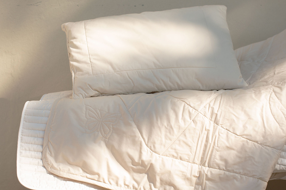 Bettdecken und Kissen aufeinander liegend