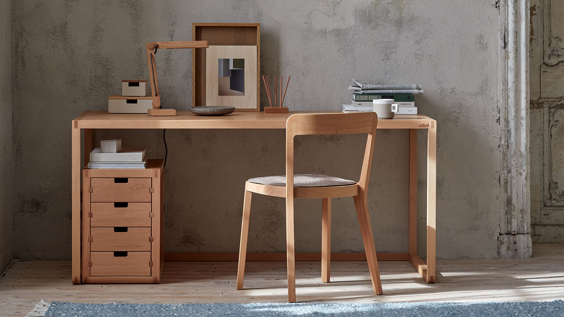 Minimalistischer Arbeitsplatz mit Holzschreibtisch und klarer reduzierter Raumgestaltung