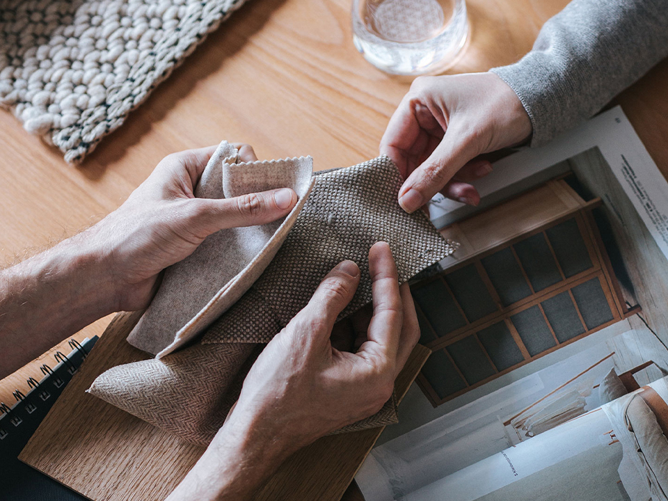 Hände greifen Stoffmuster an