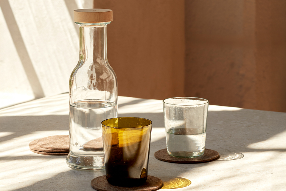 Glaskrug und Gläser auf Tisch mit warmem Licht und ruhiger Stimmung