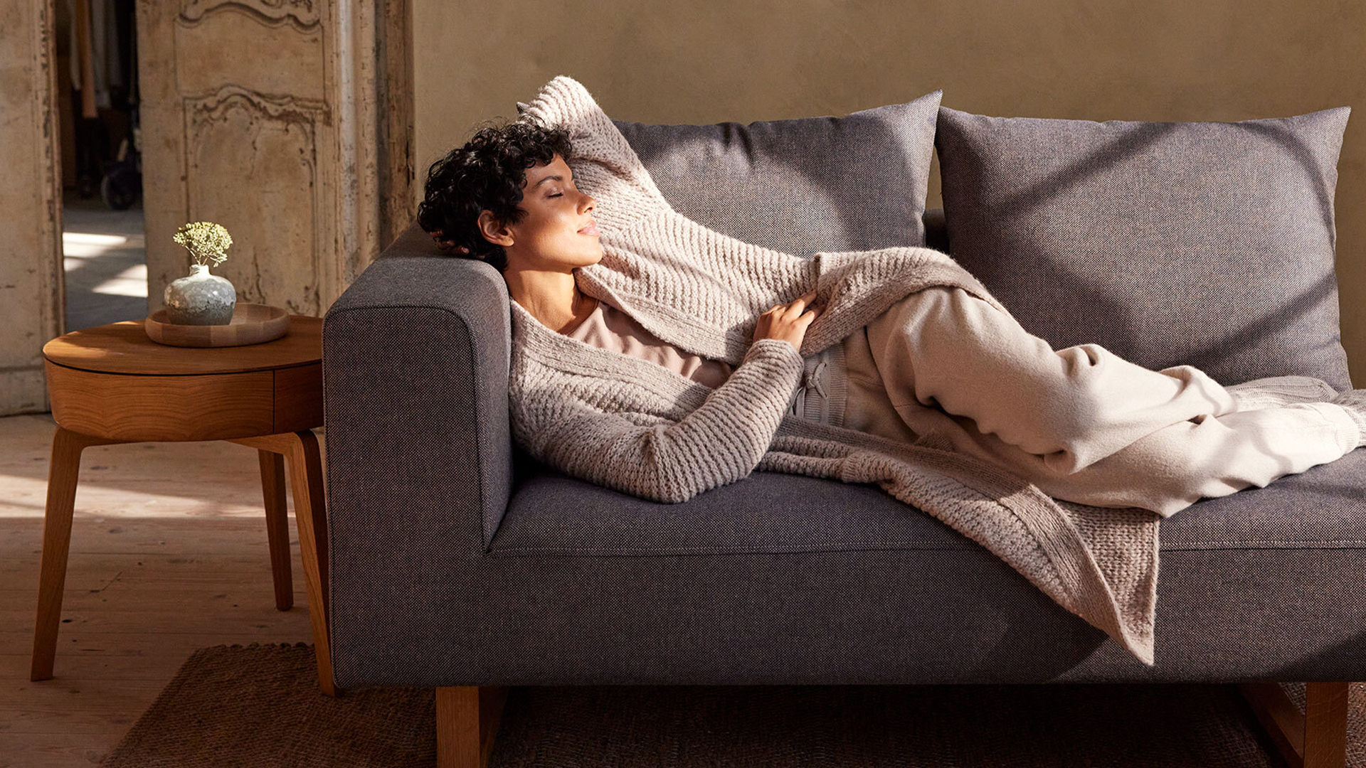 Person liegt entspannt auf Sofa und ruht sich aus