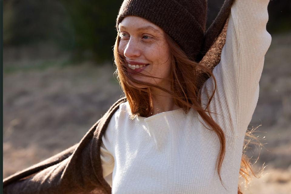 Frau mit Mütze lächelt in herbstlicher Natur