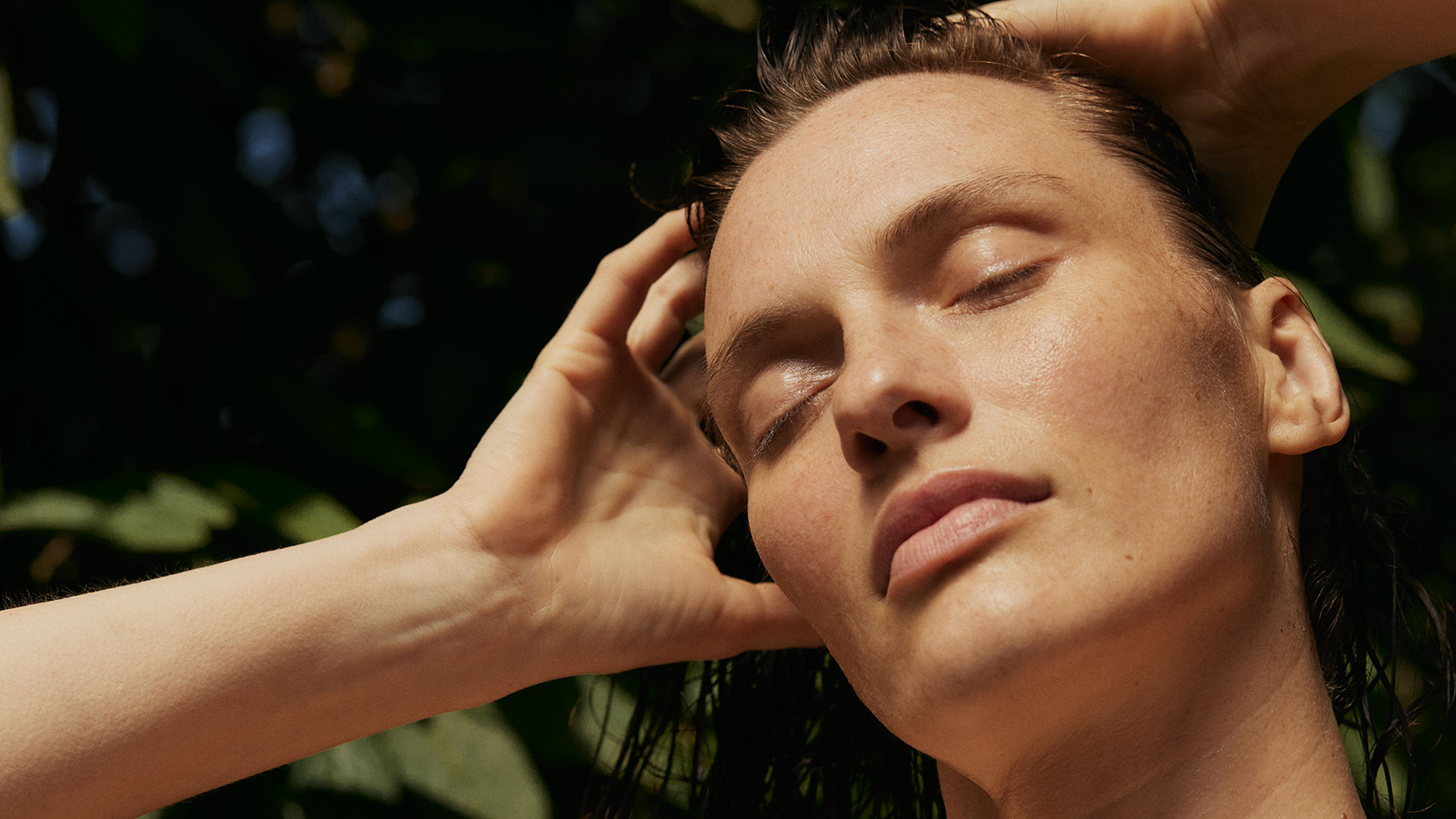 Frau fährt sich durch die nassen Haare