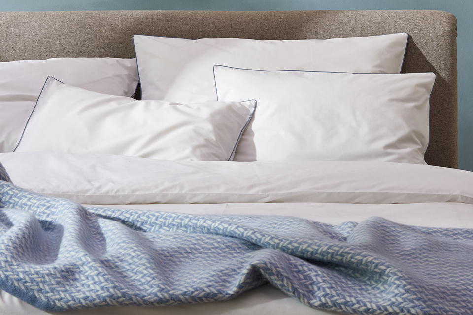 Bettwäsche Edna in blau und weiß und Wohndecke Nolan auf einem Bett mit Polsterbetthaupt