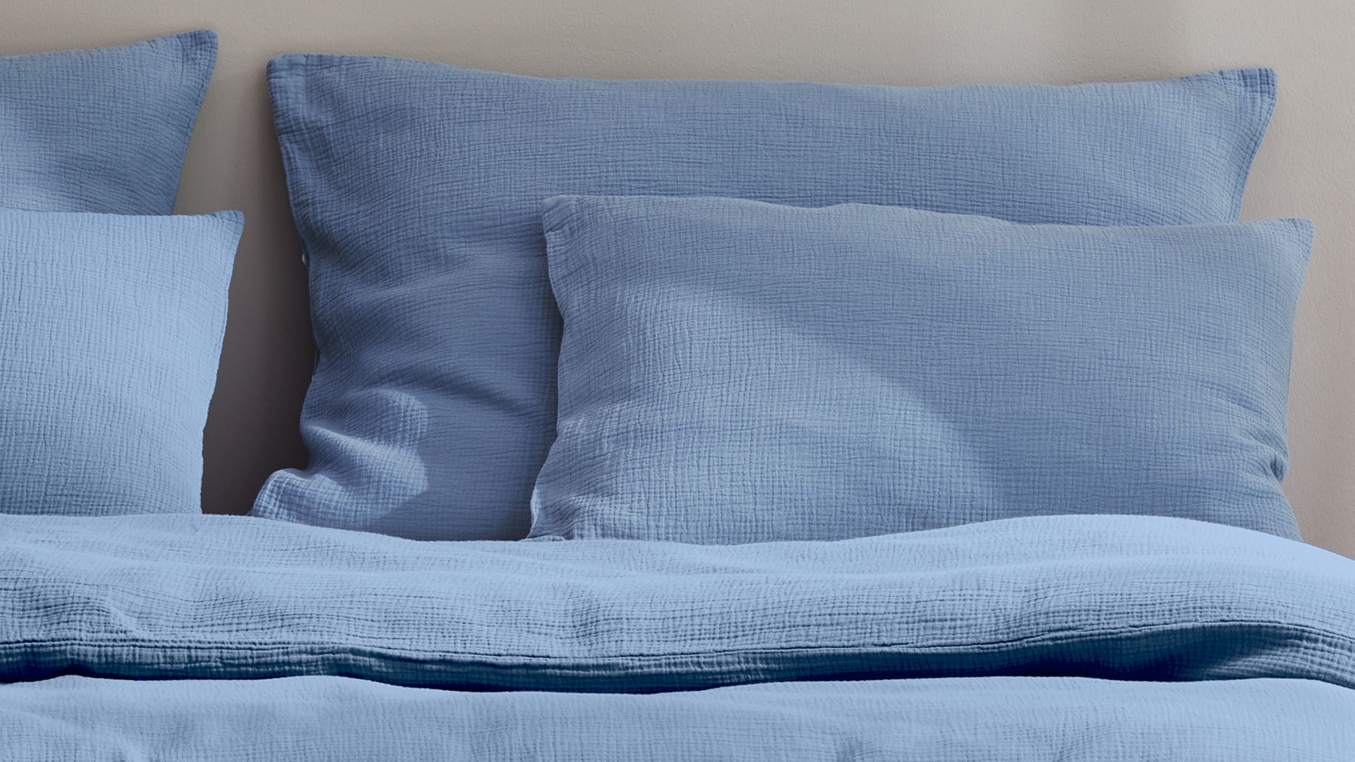 Ökologische Bettwäsche Vivien aus Baumwolle in der Farbe blau auf einem Massivholzbett