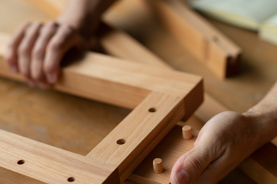 Hand beim zusammen stecken von Holzverbindungen
