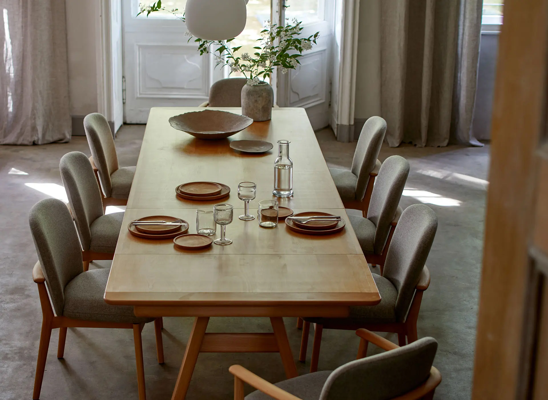 Massivholztisch mit sieben Stühlen und Dekoration im Esszimmer