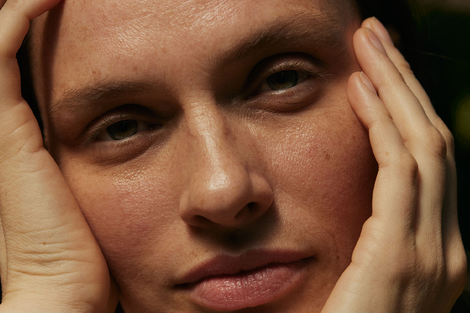 Nahaufnahme einer Frau mit ihren Händen an den Wangen