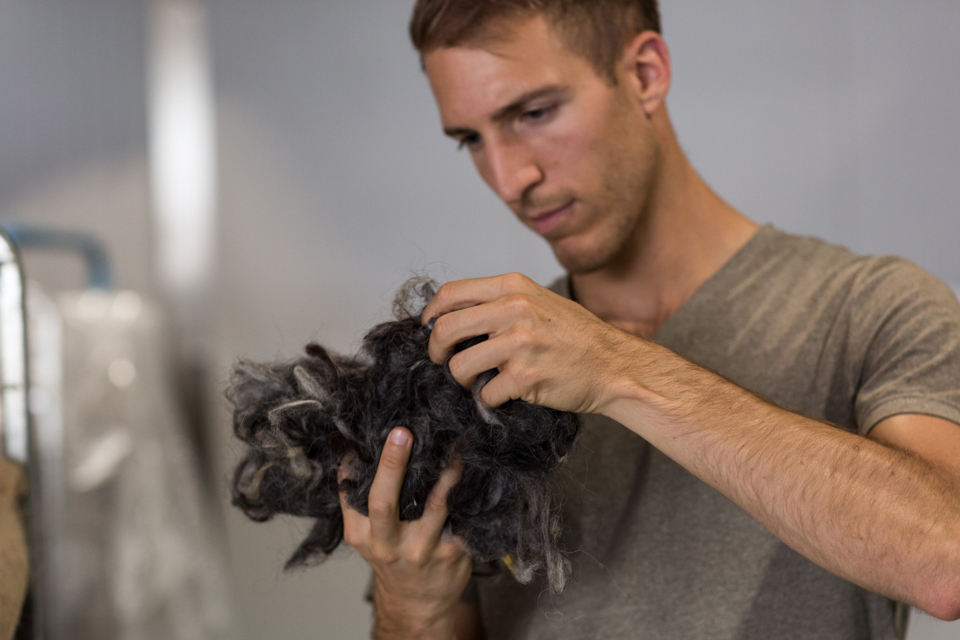 Mann hält Ballen aus Filzresten in den Händen