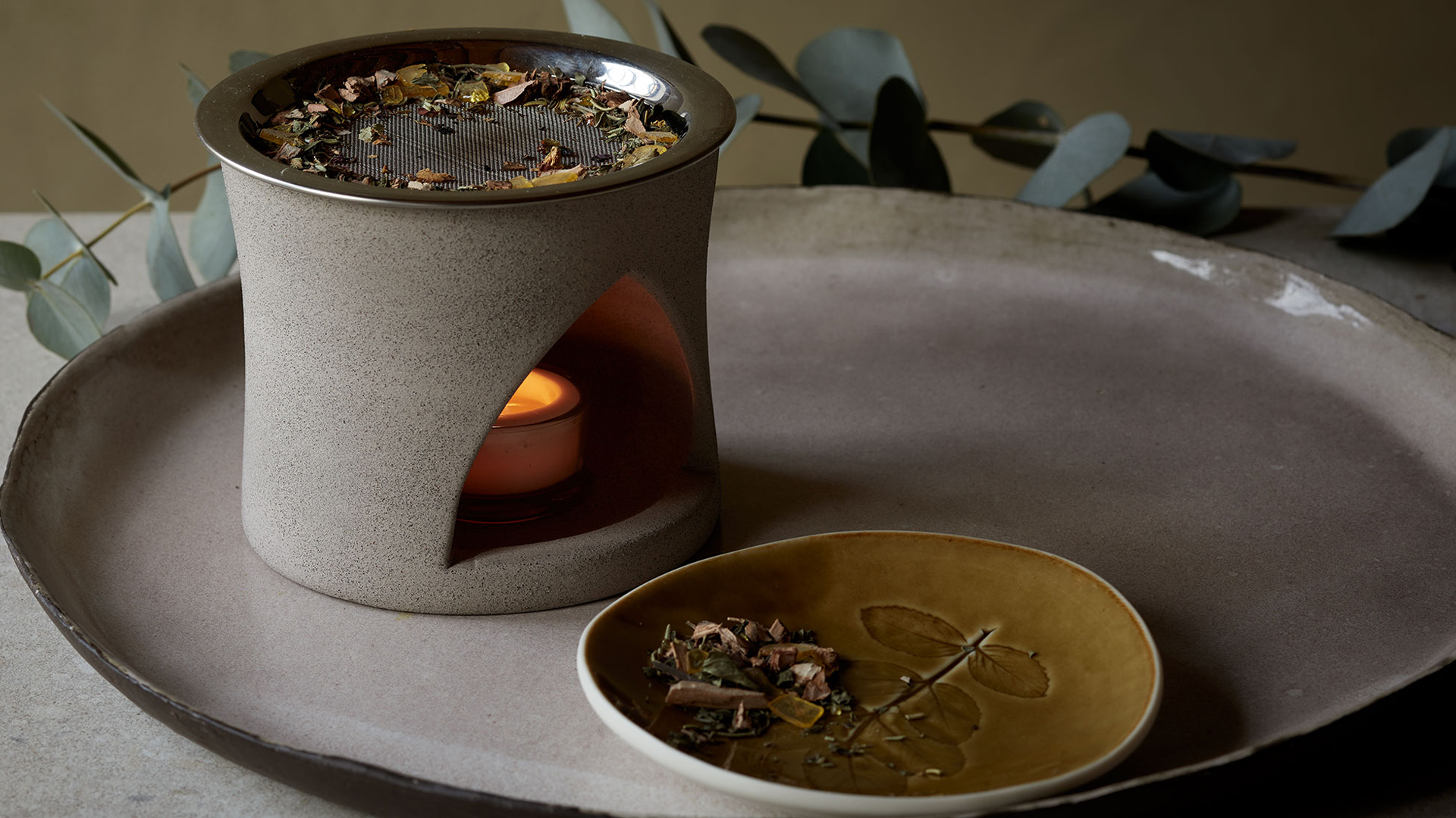 Räucherschale mit Rauch auf Teller daneben Harz und Löffel