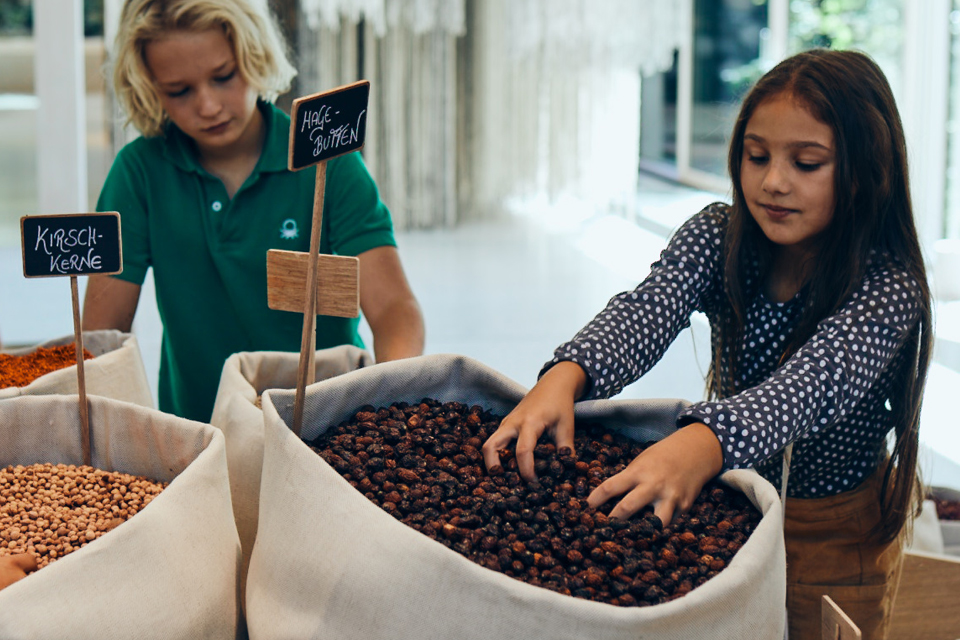 Zwei Kinder untersuchen Körner und lernen spielerisch im Workshop