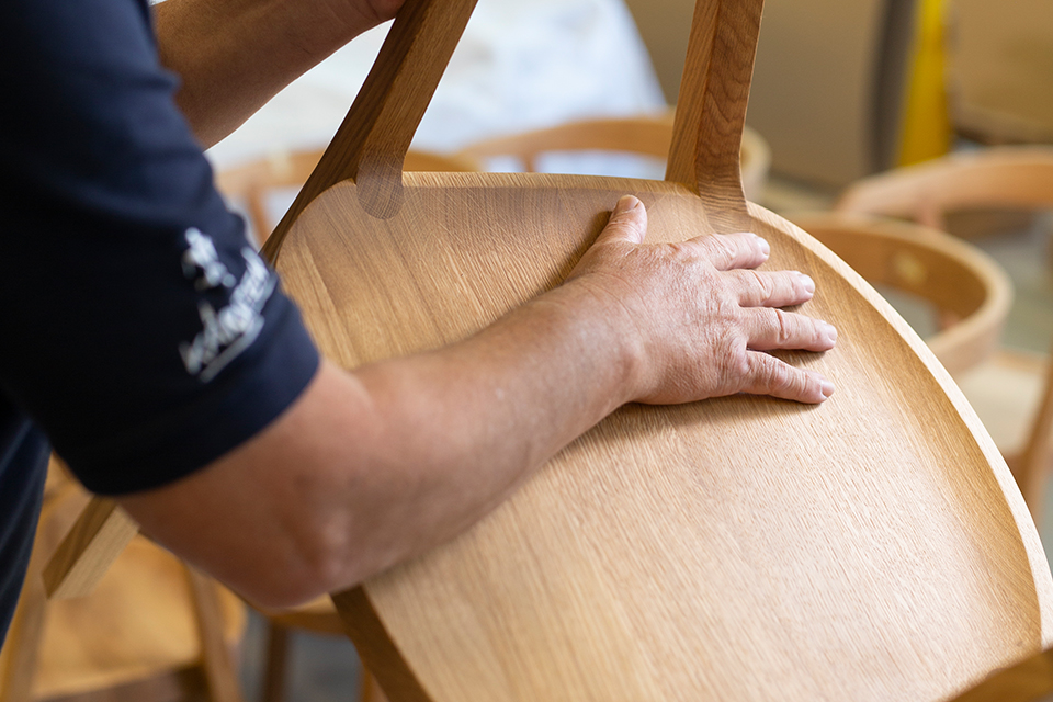 Tischler bei der finalen Inspektion eines Stuhls