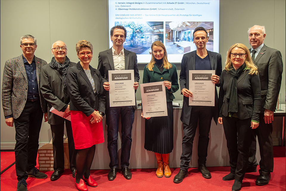 Gruppe von Menschen steht auf dem roten Teppich  mit Urkunden
