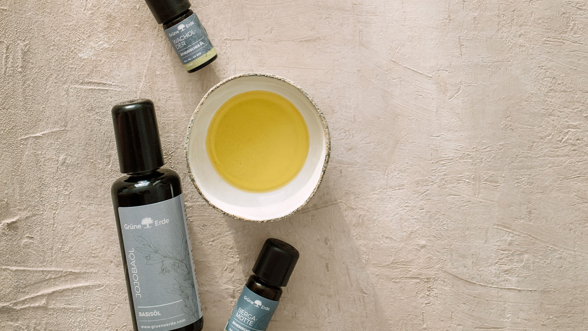 Verschiedene Öle neben einer Schüssel gefüllt mit Öl