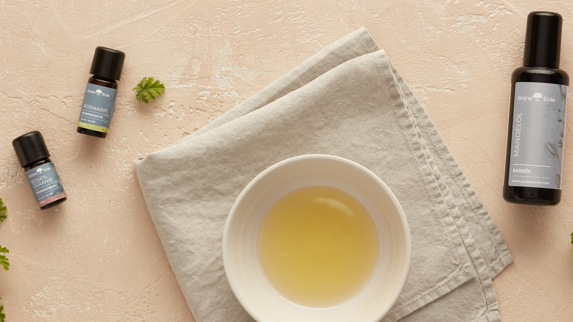 Basisöl und ätherische Öle neben einer Schale mit Öl