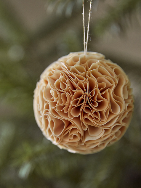 Christbaumkugel aus Holz hängt auf einem Christbaum