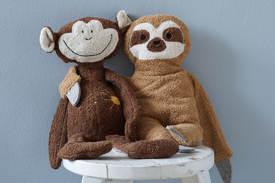 Kuscheltiere Affe Abu und Faultier auf einem Stuhl sitzend